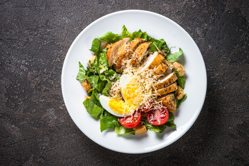 Caesar salad with chicken breast and tomatoes.