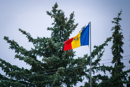 Romanian Flag on the mast. Romania flag of silk. Romanian flag on flagpole blowing in wind isolated against blue sky with copyspace.