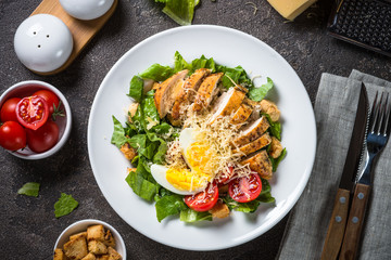 Caesar salad with chicken breast and tomatoes.