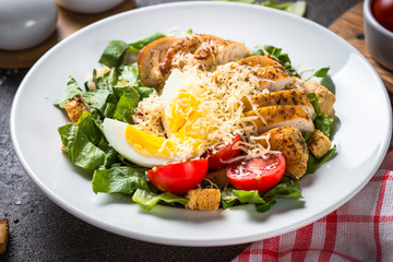 Caesar salad with chicken breast and tomatoes.
