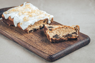 Healthy homemade carrot cake with prunes and peanuts on a wooden board.