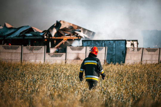 Firefighter in front of damaged landfill after fire