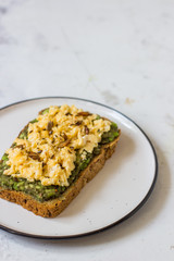 Scrambled eggs on whole wheat bread with avocado