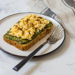 Scrambled eggs on whole wheat bread with avocado