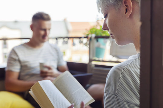 Woman reading book on balcony