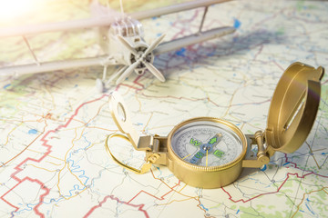 concept travel. a vintage compass on the map and an airplane in the background. Tourism, vacation.