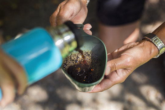 Young woman pouring drink from insulated drink container