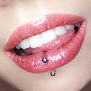 Fototapeta Girl's lips make-up lipstick lip gloss cosmetic swatch teeth tongue piercing fashion macro photo