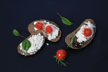 White cheese and cherry tomatoes on a slices of bread