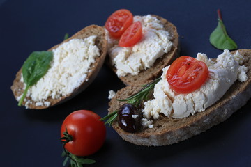 White cheese and cherry tomatoes on a slices of bread