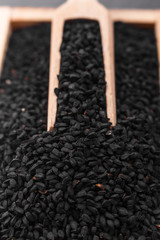 grains of black cumin and oil on the rustic background
