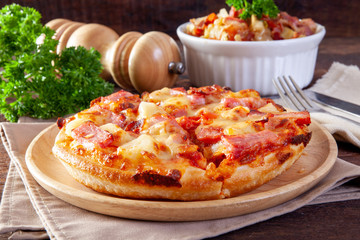 Hawaiian pizza on wood plate