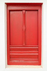 red window on white wall in temple