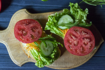 The sandwiches with vegetables on a board. Vegetarian food. Ingredients for cooking on the table.