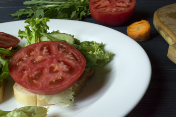 The sandwiches with vegetables on the plate. Vegetarian food. Ingredients for cooking on the table.