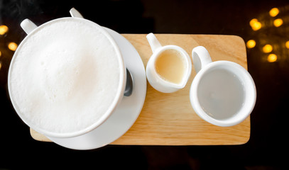 milk cup on wooden plate on glass table