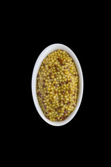 French mustard - spice, famous condiment for traditional cooking. Isolated on black. For your design. Top view.