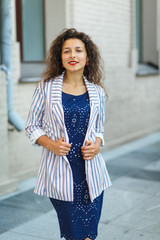 Fototapeta premium beautiful blackhaired model girl posing for cloth and bags promotion at city streets background