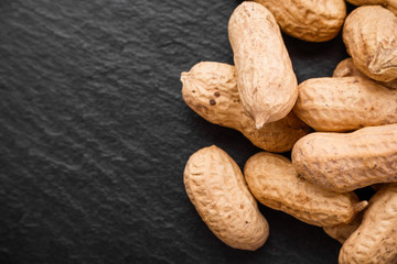fresh peanuts on a dark stone background