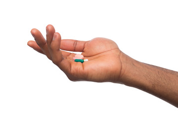 Hand holding a pill isolated on white background