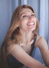 People and hope concept - close up of happy woman with long hear in gray lingerie