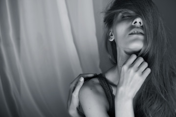 Black and white portrait of a girl with passion and closed eyes on a white background. Horizontal position. Fashion
