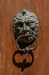 Close-up of face-shaped knocker on wooden door in Aix-en-Provence, a pleasant and lively town in...