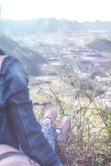 Young woman sitting on a rock with backpack. Bali island. Volcano Batur.