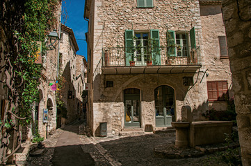 Alley with square, stone houses and fountain in Saint-Paul-de-Vence, stunning medieval town completely preserved. In Provence region, southeastern France.