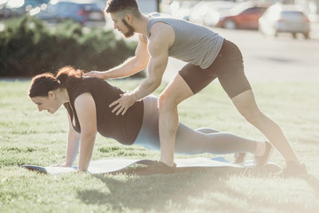 Obese woman doing exercise with instructor support