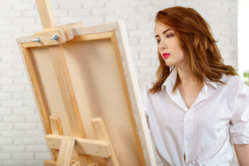 Beautiful young woman painter at work