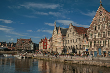 Naklejka premium Old buildings in front of the canal with boats in Ghent. In addition to intense cultural life, the city is full of Gothic and Flemish style buildings. Northern Belgium.
