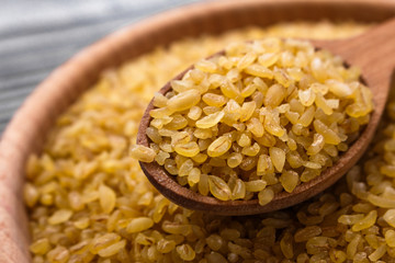 raw bulgur on a rustic wooden background