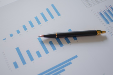 Many charts and graphs with magnifying glass and many pencil. Reflection light and flare. Concept image of data gathering and statistical working.