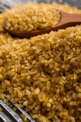 raw bulgur on a rustic wooden background