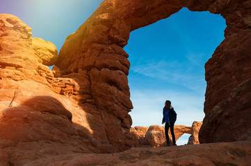 Young woman traveler with backpack hiking the Turret Arch, Arches National Park in Utah