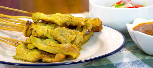 Pork Satay with peanut sauce and vegetables salad sauce on napery cloth