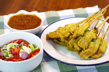 Pork Satay with peanut sauce and vegetables salad sauce on napery cloth