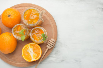 Orange jam in a glass jar on a light background. With an empty space for writing