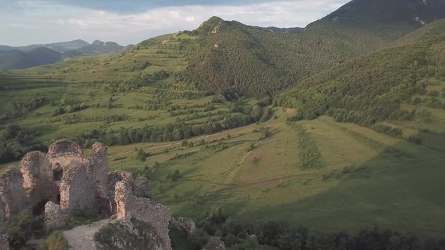 Aerial view. Flying backwards over the ruins of an old medieval stronghold in Romania. Morning light
