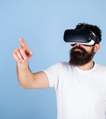 Man with hipster beard in VR glasses using digital touch screen. Bearded man interacting with cyber...
