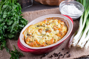 Baked casserole with a pumpkin on a wooden background