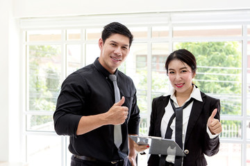 Business ideas, teamwork and people. Man and women showing thumbs up in office.