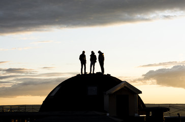 silhouettes of three pople on sunset