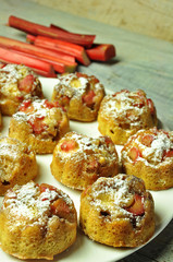 Muffins with rhubarb on a white plate on a wooden background