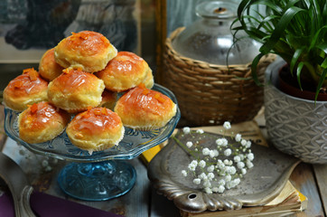 Baked donuts with icing on a glass plateau on a rustic background