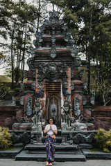 Obraz premium .Young and cheerful tourist enjoying the island of Bali in Indonesia. Knowing ancient Hindu temples, very spiritual places. Travel Photography. Lifestyle..