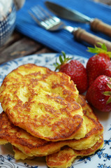 Pancakes with apples on a plate. Strawberries on a plate next to pies