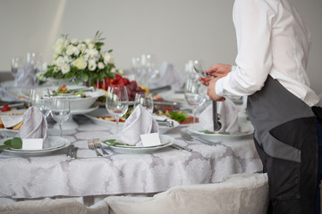 Restaurant waiter serving table with food