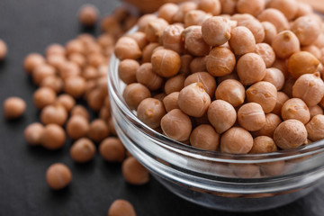 uncooked chickpeas on a dark stone background